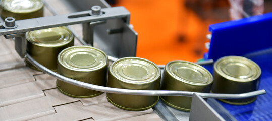 Canned food products on conveyor belt in distribution warehouse. parcels transportation system...