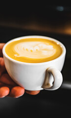 Barista hand hold cup cappuccino Coffee with espresso and milk in cafe