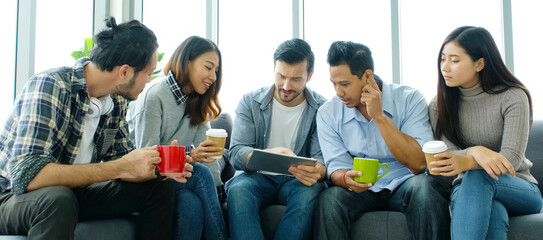Group of happy creative team discussinng while taking coffee break at office