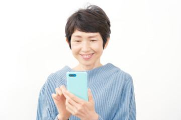 Fototapeta premium スマホを使う中年女性 白背景