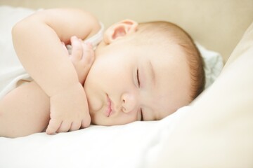 Baby sleeping on white sheet