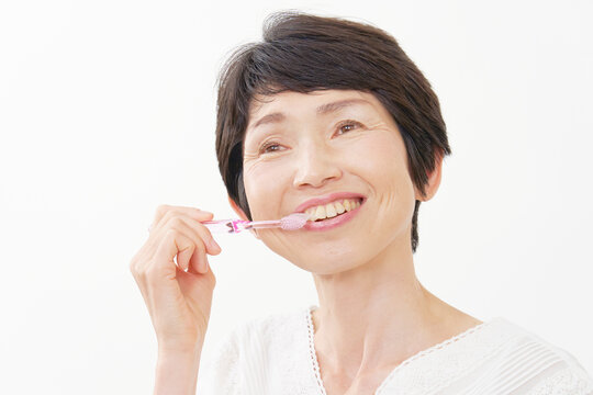 歯磨きをする中年女性　白背景