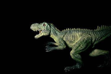 Toy carnivorous dinosaur on a black background. Prehistoric predatory dinosaur