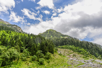 Obraz premium Lush green mountains with clouds and blue sky landscape
