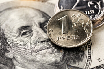 Russian ruble coin on background of dollar bill.Concept of ruble devaluation, inflation in Russia.The concept of depreciation, sanctions, financial crisis, war.Stop war.