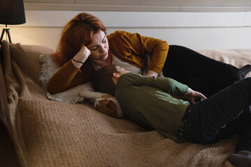 Middle age woman mother with son. Female hugging her lovely teen child in bedroom in the evening. Copy space. Adorable family concept.