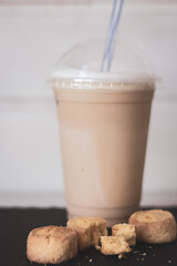 Iced coffee latte with cookies. Coffee to go with fresh bakery. Cold latte with drinking straw and cookies. Cold coffee with cakes. Breakfast dessert. Summer drinks. Cappuccino with homemade biscuit.