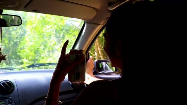 Beautiful pretty woman drinks beer while driving jungle Mexico.