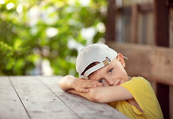 he boy put his hands under his head and lay down on the table