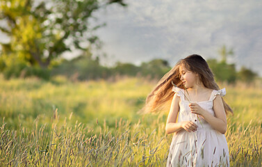 girl in the field hair fluttering in the wind