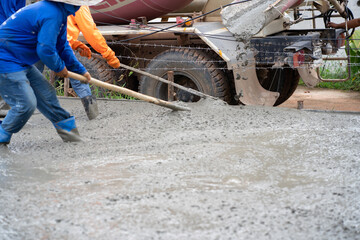 Construction workers are pouring concrete pavement at the construction site.