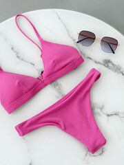 Pink swimsuit and sunglasses. Summer clothes Still life