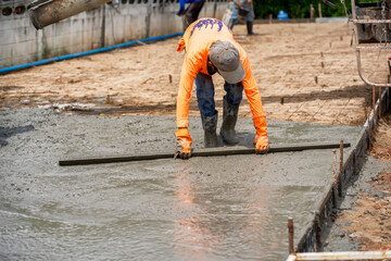 Construction workers are pouring concrete pavement at the construction site.