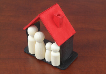 Family people figures in wooden house. Happy family, real estate and insurance concept.