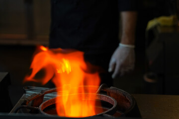 blazing flame in the blur with the light on the stove. photo inside. gas.