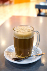 Glass cup with cocoa on a table in a cafe