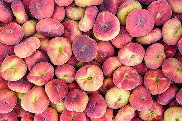 Paraguayan sweet peaches stacked in a container box to the raw for sale, overhead photo.