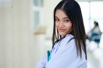 Female asian doctor or nurse in white uniform look at camera standing in patient Clean and room with a bed in the new medical center. Healthcare medical and medicine concept.