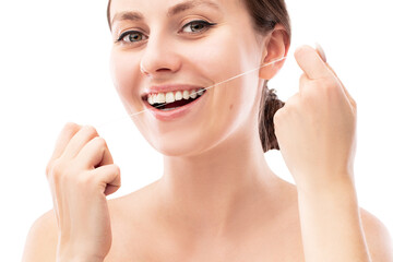 Smiling woman using tooth floss cleaning and caring for perfect teeth posing on isolated white ...
