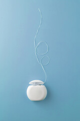 Dental floss case on blue background. Daily dental care. Advertising 