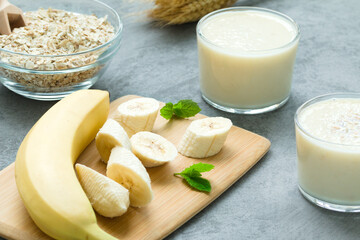 milkshake and ripe bananas with mint leaves on a wooden board