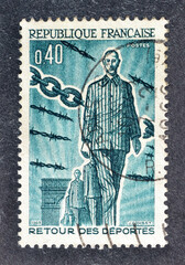 Cancelled postage stamp printed by France, that shows Return of Deportees from concentration camps, circa 1965.