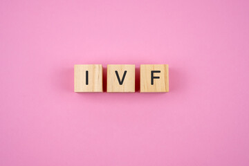 IVF text on wood block pink background