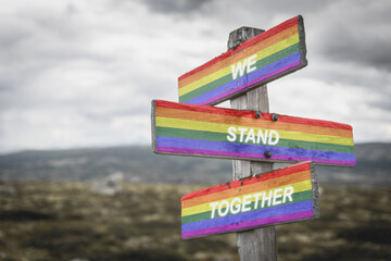 we stand together text quote on wooden signpost crossroad outdoors in nature. Freedom and lgbtq...
