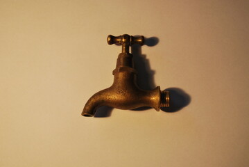 Fototapeta antique object - faucet - made of brass on a light background, under warm artificial lighting obraz
