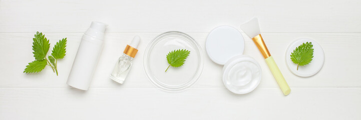 Natural cosmetics with nettle leaves. Top view. Cream, serum, bottle lotion.