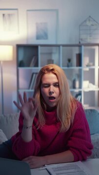 Everything ok. Positive woman. Successful agreement. Smiling winking casual lady showing okay sign sitting desk light room interior looped meme expression vertical.