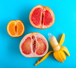 Top view citrus and banana in condom on blue background.