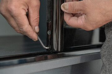 Assembly of mirrored doors to a sliding wardrobe, installation of a case by means of the hexagonal screw.