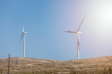 View of wind turbines at sunset. Wind power or wind energy is mostly the use of wind turbines to...