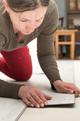 Installation of quartz vinyl floor, female master installs the floor.