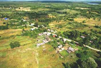 Fototapeta premium Rural building and farmhouse in countryside. Country houses in countryside, aerial view. Building a Houses in сountry. Village with wooden house. Suburban house in rural. Roofs of village home.