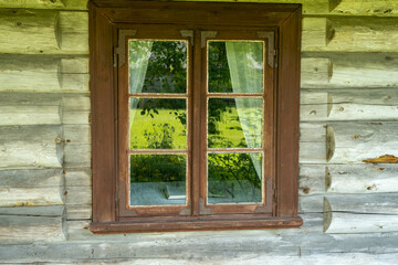 Window with brown shutters in old wooden wall