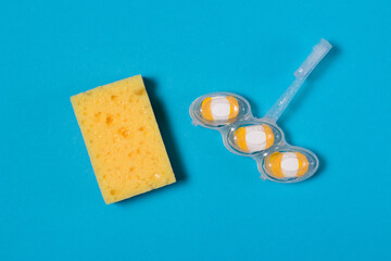 Flatlay, toilet cleaner, white-yellow toilet with lemon scent and yellow cleaning sponge on a blue background with copy space. The concept of cleanliness and cleaning.