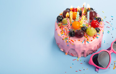 Fresh delicious birthday cake with candles on table against color background