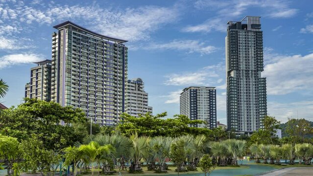 Time lapse of morning sunrise and moving clouds behind hotel buildings of Sri Racha, Chonburi in Thailand