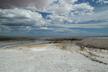 Natural salt flats. Industry and open cast mining. Saltworks and salt natural fields under a dramatic and stormy sky.