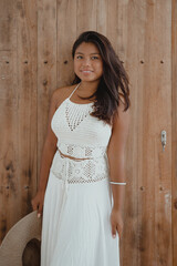 Fototapeta premium young happy Indonesian woman in white maxi dress with hat in hand