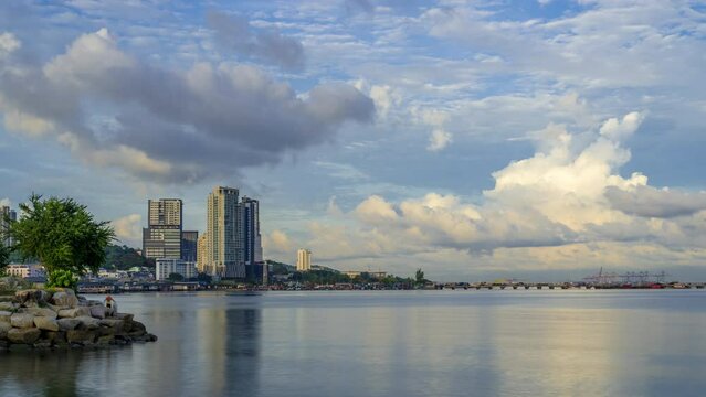 Timelapse of beautiful morning sunrise and moving clouds in the sky over the city and ocean in Sri Racha, Chonburi, Thailand