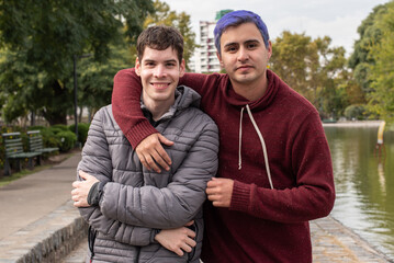 Fototapeta premium Gay male couple hugging and looking at camera outdoors