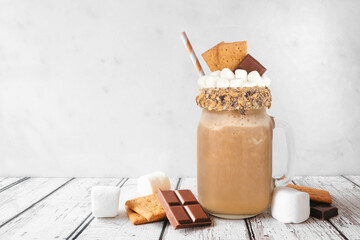 Smores drink in a mason jar glass with ingredients. Side view scene against a white background....