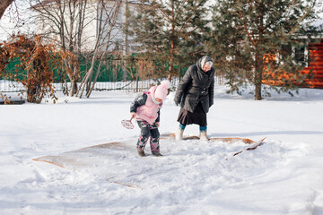 Woman and child are cleaning carpet. Family is engaged in traditional method of ecological carpet...