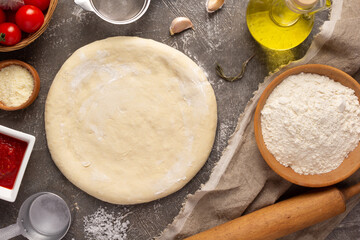 Pizza or dough for bread with ingredients at table. Pizza recipe homemade at tabletop background