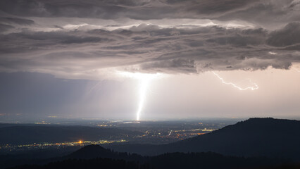 Naklejka na ściany i meble Powerful lightning strike near Plittersdorf in the district of Rastatt during a summer thunderstorm
