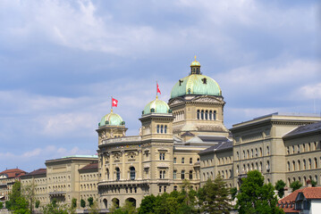 Federal Palace of Switzerland (German Bundeshaus), residence of national Swiss government and parliament, on a blue cloudy summer day. Photo taken June 16th, 2022, Bern, Switzerland.