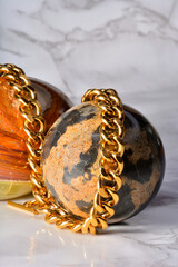 golden gold chain , to be used as necklace or bracelete in a composition with marble eggs
